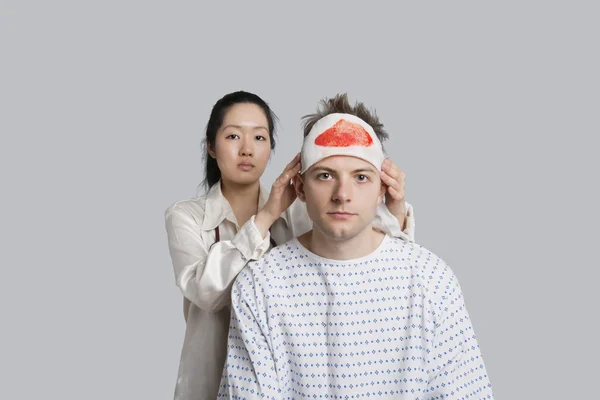 Retrato de médico feminino examinando paciente ferido do sexo masculino — Fotografia de Stock