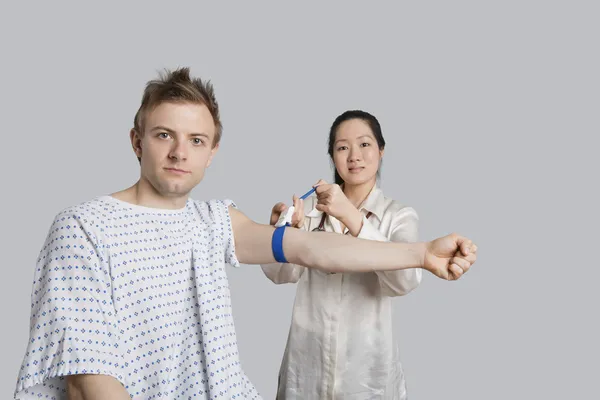 Portrait of male patient with doctor preparing him for a blood test — Stock Photo, Image