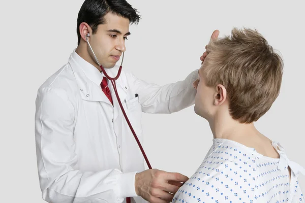 Indian doctor examining male patient with stethoscope — Stock Photo, Image