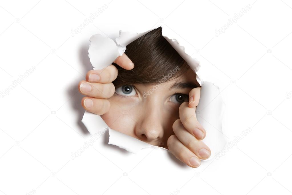 Middle eastern woman peeking from ripped white paper hole