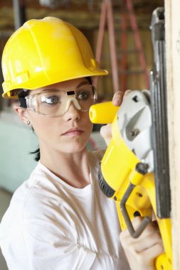 ciddi Bayan inşaat işçisi bir güç ile ahşap kesme gördüm