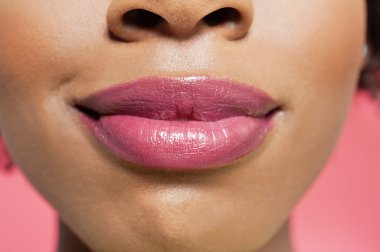 Afrikalı-Amerikalı bir kadının renkli arka plan üzerinde kırmızı dudaklar görünümünü yakın çekim