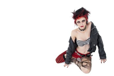 Beyaz arka plan üzerinde oturan güzel genç punk kadın portresi