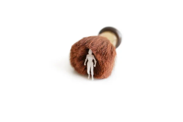 Figurina com uma escova de barbear sobre fundo branco — Fotografia de Stock