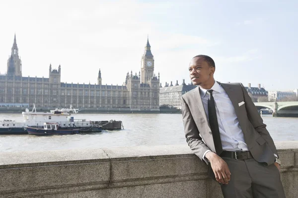 African American businessman leaning with hand in pocket — Stock Photo, Image