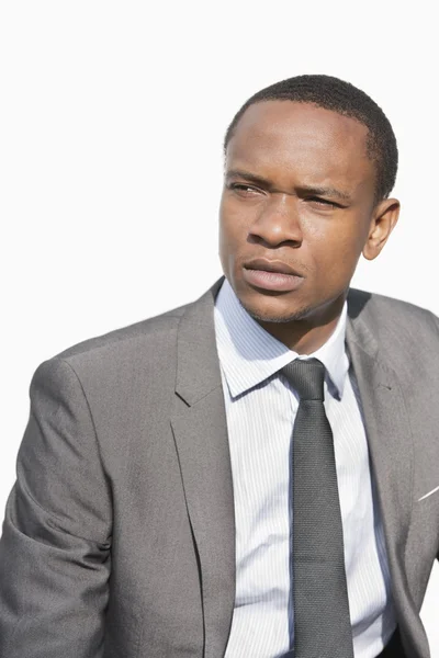 Serious African American businessman looking away over white background — Stock Photo, Image