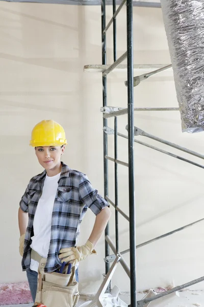 Retrato de una mujer adulta de pie con las manos en las caderas en el sitio de construcción — Foto de Stock