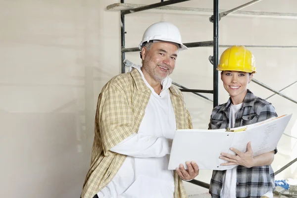 Portrait of happy team of architect with paper documents at construction site — Stock Photo, Image