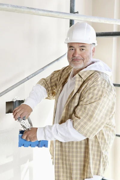 Портрет взрослого мужчины, держащего строительную технику — стоковое фото
