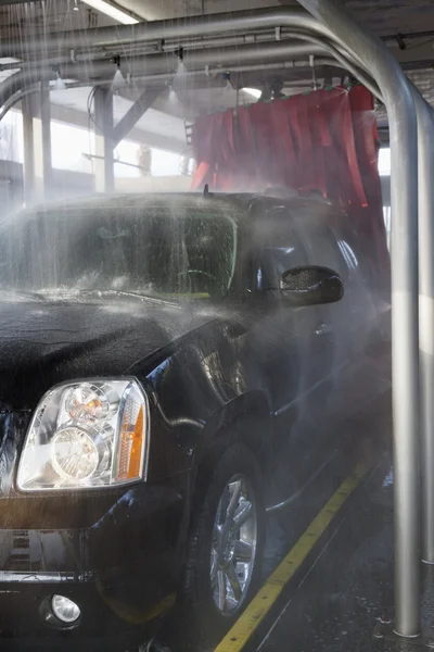 Sproeien van water op auto in car wash — Stockfoto