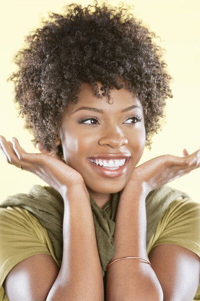 Happy African American woman looking away over colored background