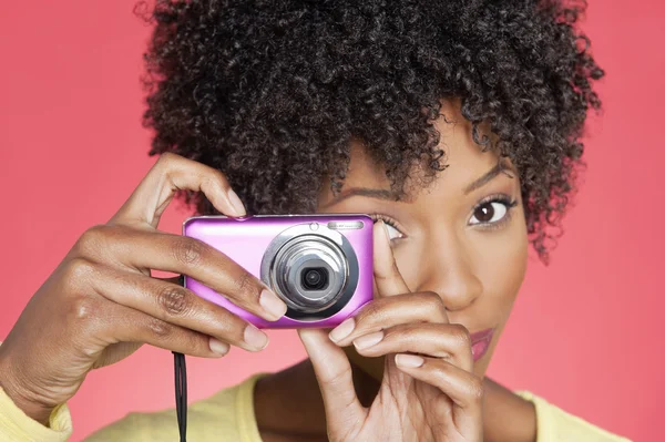 Ritratto di una donna afroamericana che scatta foto dalla macchina fotografica su sfondo colorato — Foto Stock