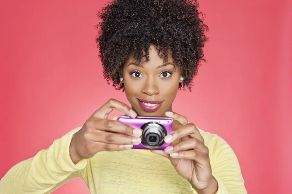 Портрет жінка тримаючи камеру на кольоровому фоні — стокове фото