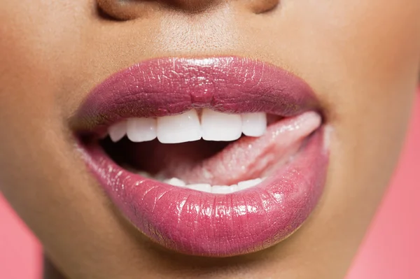 Cropped image of woman licking red lipstick — Stock Photo, Image