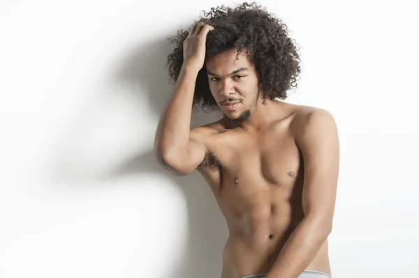 Retrato de jovem com posando com a mão no cabelo sobre fundo branco — Fotografia de Stock