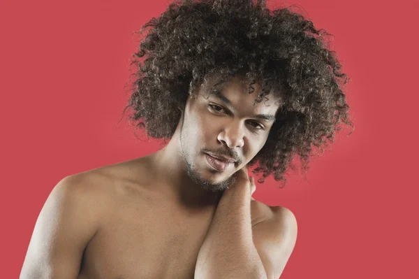 Portrét mladého muže s kudrnatými vlasy nad barevným pozadím — Stock fotografie