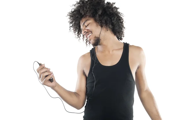 Happy young man listening to mp3 player over white background — Stock Photo, Image