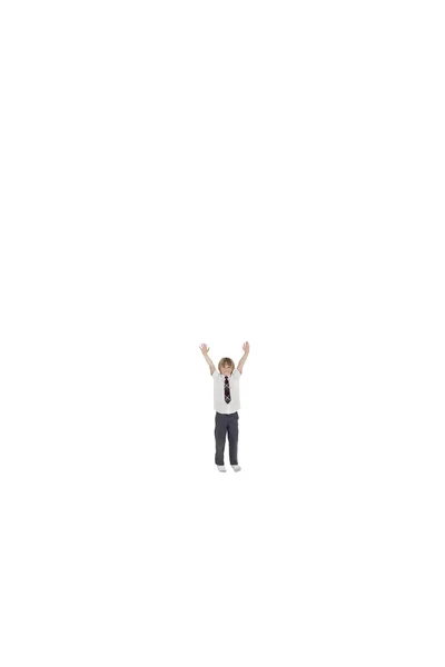 Elementary boy standing at distance with arms raised over white background — Stock Photo, Image