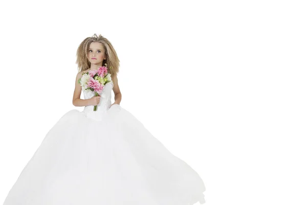 Menina no vestido de noiva segurando buquê de flores enquanto olha para o fundo branco — Fotografia de Stock