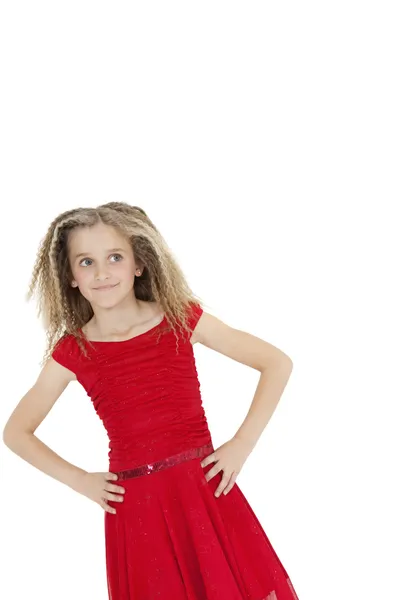 Tilt image of girl wearing red frock looking sideways with hands on hips over white background — Stock Photo, Image