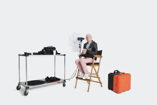 Fotograaf zittend op de stoel van de bestuurder met voorzieningen in studio — Stockfoto