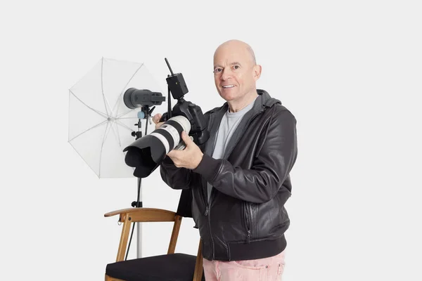 Retrato de homem idoso feliz com câmera em pé no estúdio do fotógrafo — Fotografia de Stock