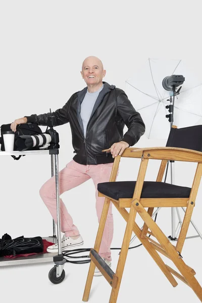 Retrato de comprimento total de um fotógrafo sênior feliz com equipamentos em estúdio — Fotografia de Stock