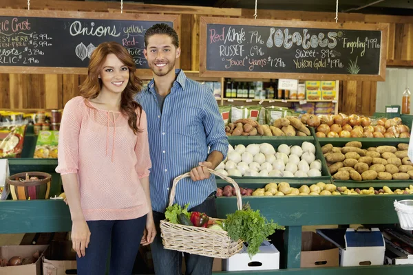 Портрет счастливой молодой пары на овощном рынке — стоковое фото
