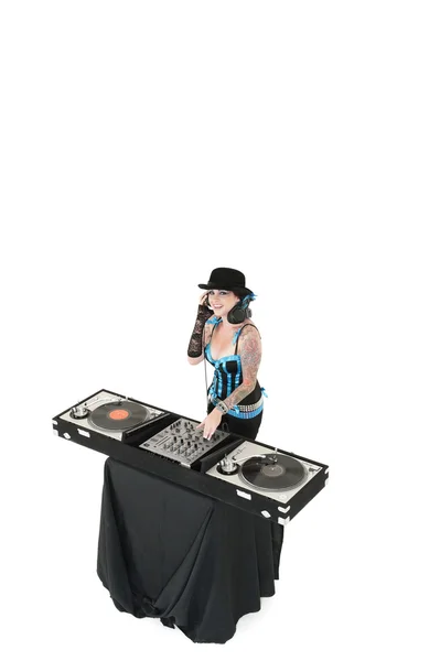 Retrato de jovem DJ com equipamento de mistura de som usando chapéu sobre fundo branco — Fotografia de Stock