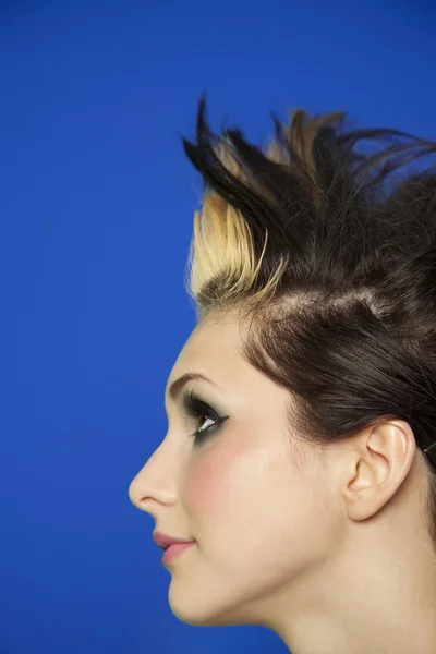 Vue latérale de la jeune femme avec des cheveux pointillés sur fond coloré — Photo