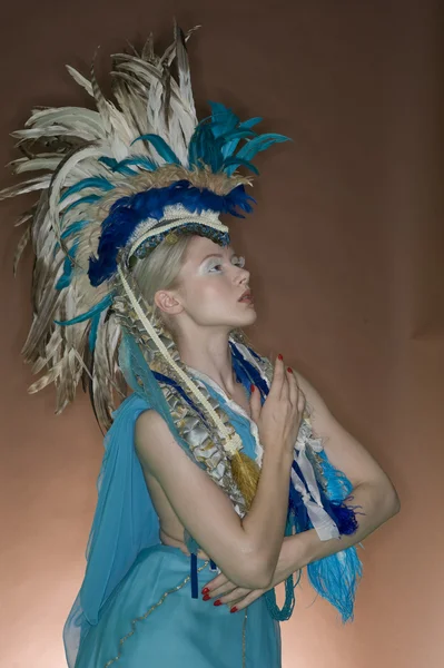 Hermosa mujer posando en traje de plumas sobre fondo de color —  Fotos de Stock