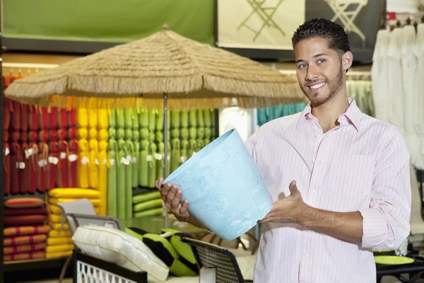 Joven feliz sosteniendo un recuerdo en la tienda —  Fotos de Stock