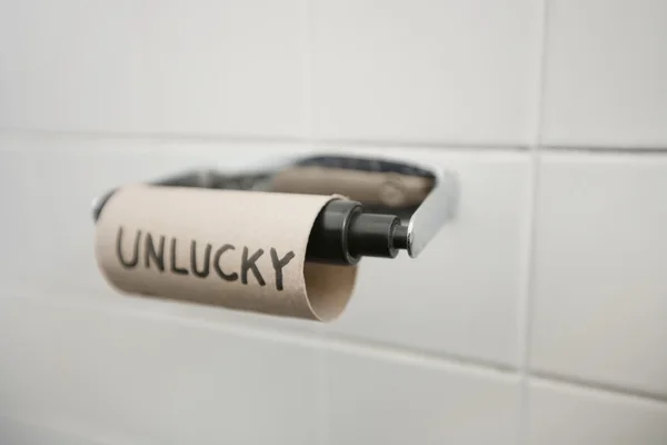 Close-up of text written on empty toilet paper roll in bathroom — Stock Photo, Image