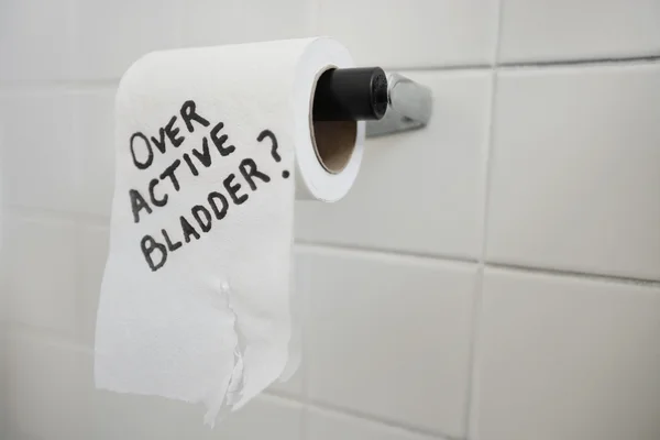 Close-up of toilet paper roll with text asking about bladder issues — Stock Photo, Image