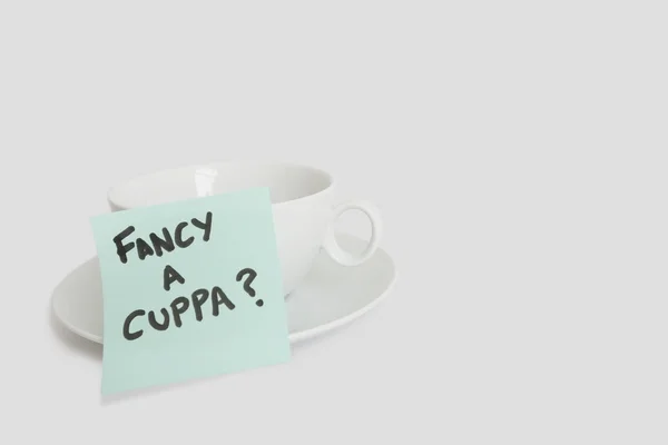 Close-up of sticky notepad stuck to empty coffee cup over white background — Stock Photo, Image