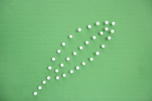 Close-up view of push pins forming leaf over colored background — Stock Photo, Image