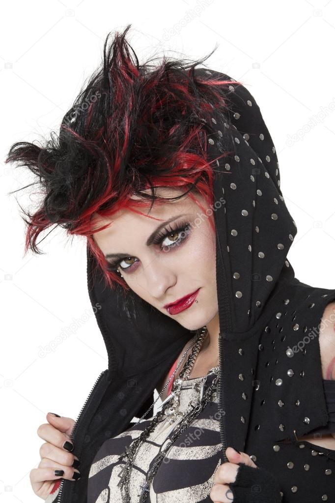 Close-up portrait of young punk woman wearing hood over white background