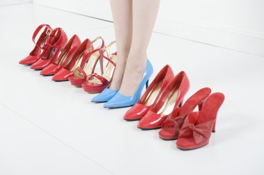 In Blue High Heels Amid Red Shoes clipart