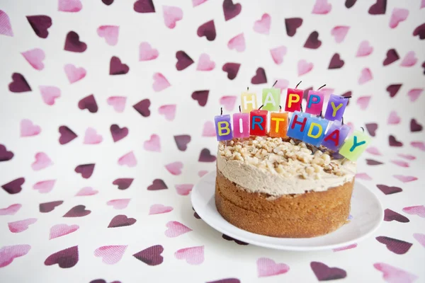 Close-up van birthday kaarsen op taart over hartvormige achtergrond — Stockfoto