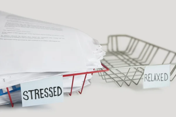 Stack of paperwork in stressed tray with empty relaxed platter over white background — Stock Photo, Image