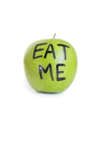Close-up of text on a granny smith apple reading eat me over white background — Stock Photo, Image