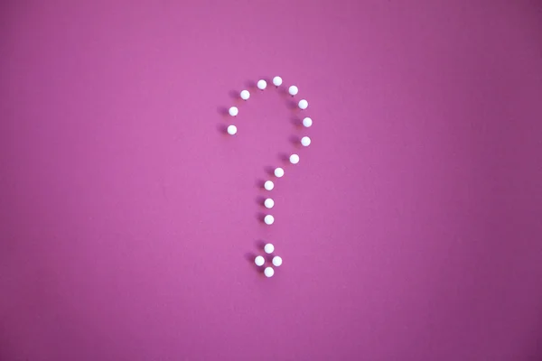 Close-up of push pins forming question mark over pink background — Stock Photo, Image