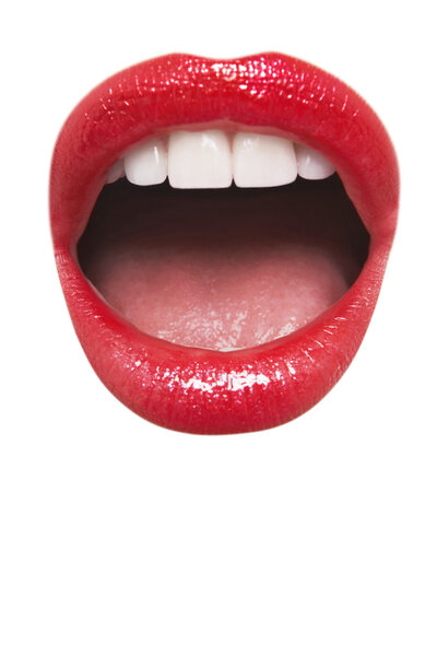 Close-up view of female wearing red lipstick with mouth open over white background