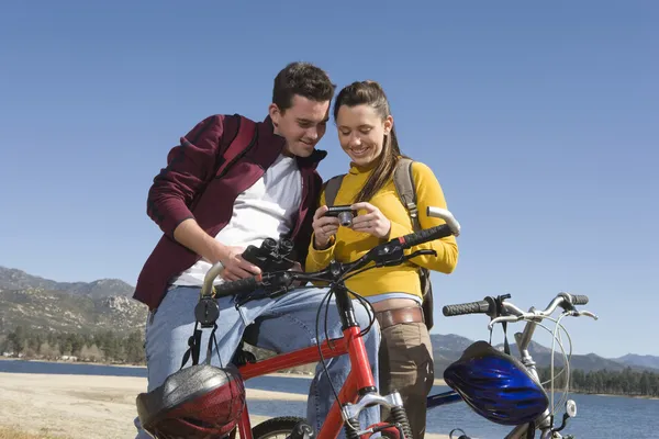 Mountainbikecyklister med digital kamera mot blå himmel — Stockfoto