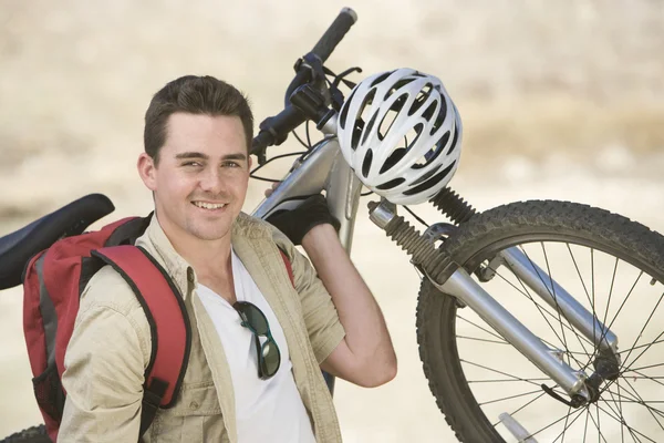 Hombre llevando bicicleta de montaña — Foto de Stock