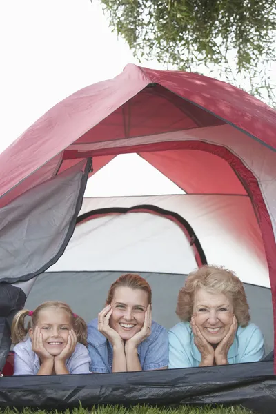 Mormor, dotter och barnbarn leende från tält — Stockfoto