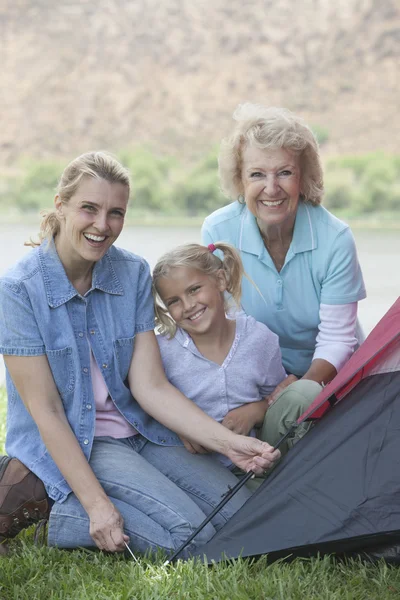 Mulher com mãe e filha colocando uma tenda — Fotografia de Stock