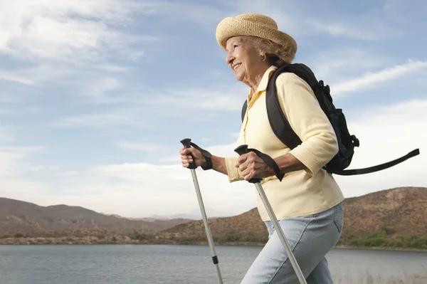 Senior vrouw wandelen naast lake — Stockfoto