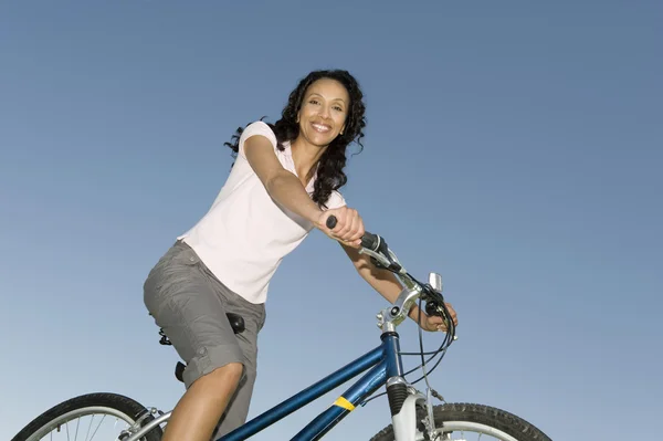 女性に対するサイクリング澄んだ青い空 — ストック写真