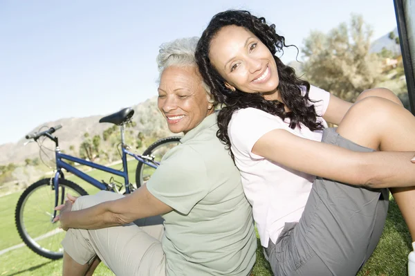 Mor och dotter sitta i parken med mountainbike — Stockfoto